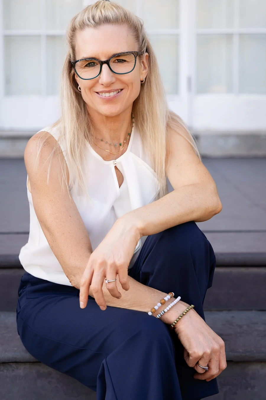 Charlotte Sinclair seated on stone steps, relaxed and smiling.
